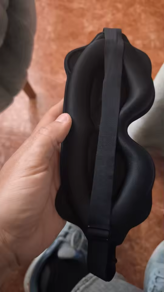 Customer holding the black eye mask showing its depth and strap