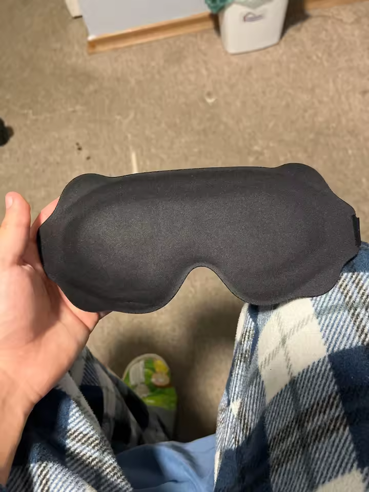 Customer holding the black eye mask, front view